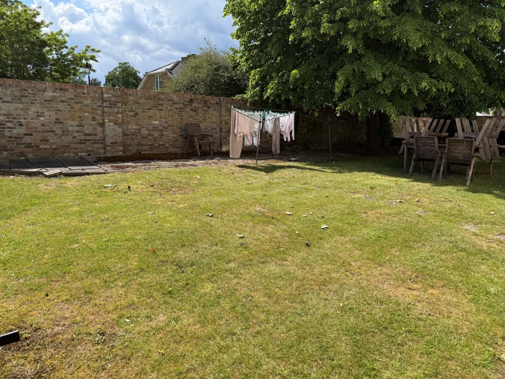Lot: 128 - TWO-BEDROOM FLAT WITH GARAGE IN NEED OF UPDATING - Rear gardens with lawn and brick wall